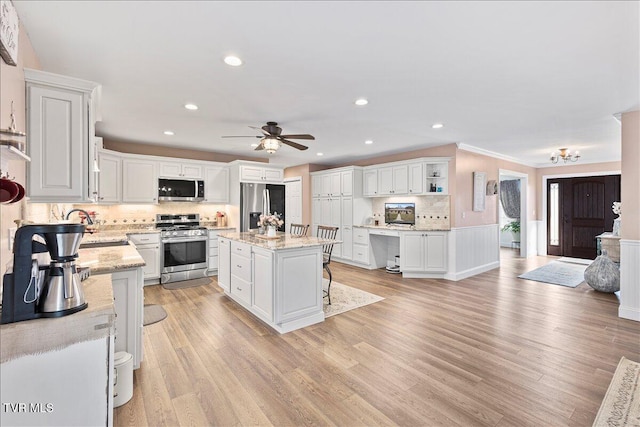 kitchen with light wood-style flooring, white cabinets, appliances with stainless steel finishes, decorative backsplash, and open shelves