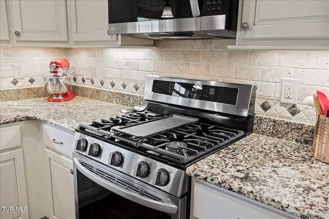 kitchen with light stone countertops, white cabinetry, tasteful backsplash, and appliances with stainless steel finishes