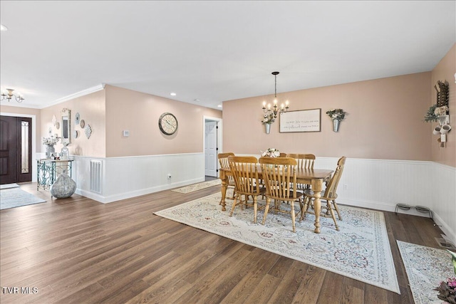 dining area featuring a chandelier, recessed lighting, a wainscoted wall, and wood finished floors