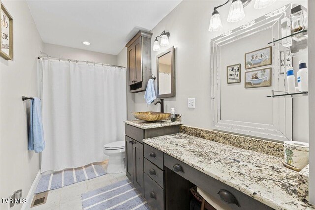 bathroom featuring curtained shower, visible vents, toilet, vanity, and tile patterned floors