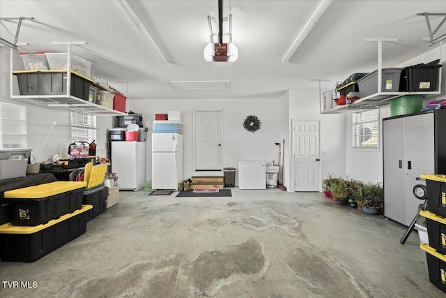 garage with freestanding refrigerator and a garage door opener