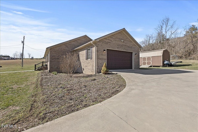 view of side of home featuring an outbuilding, an attached garage, brick siding, concrete driveway, and a storage unit