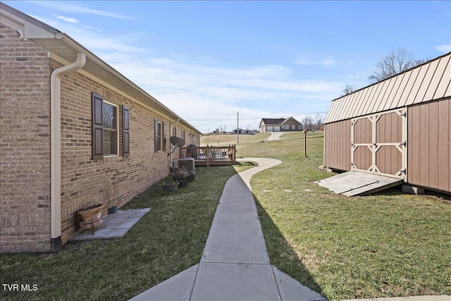 view of yard with an outbuilding, a wooden deck, and a shed