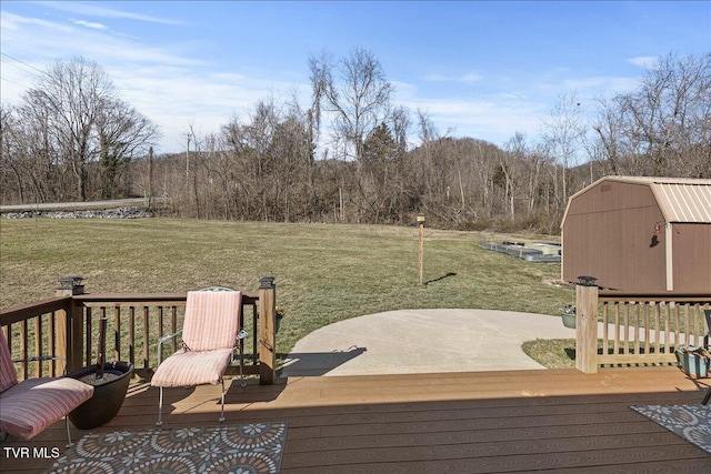 wooden terrace featuring an outbuilding, a yard, and a storage unit