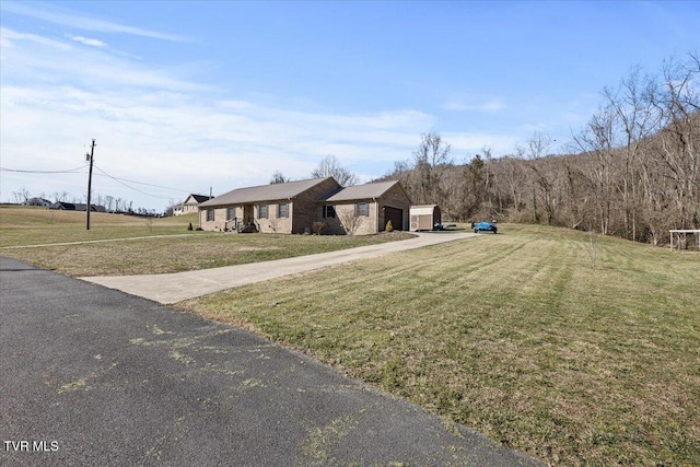 view of front of property featuring an attached garage, concrete driveway, and a front yard