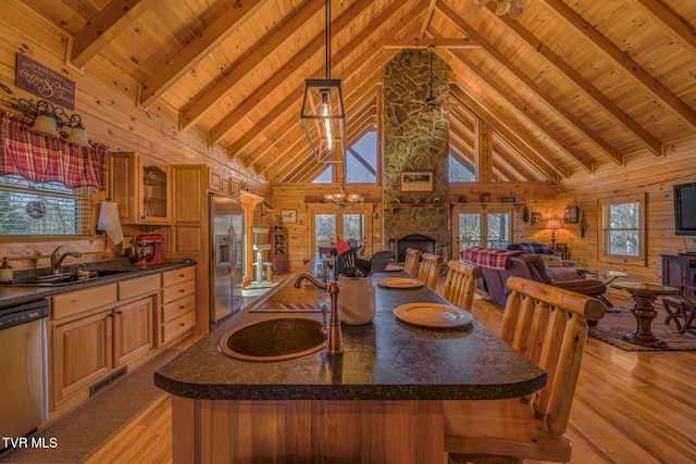 dining room featuring wooden ceiling, beamed ceiling, wooden walls, and light wood finished floors