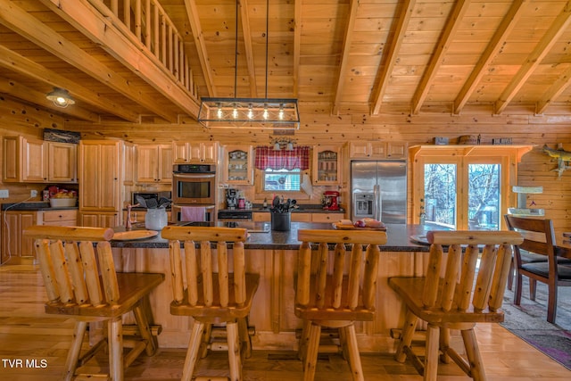 kitchen with dark countertops, wood ceiling, appliances with stainless steel finishes, wood walls, and beam ceiling