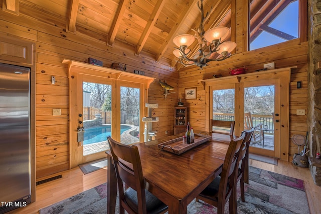 dining area with a wealth of natural light and wood walls