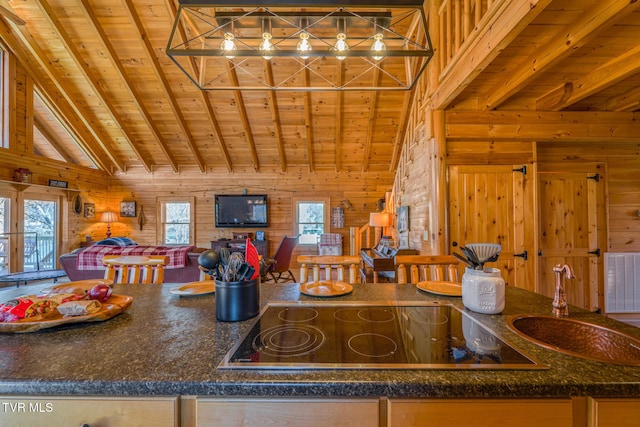 kitchen with wood ceiling, wooden walls, black electric cooktop, and a sink