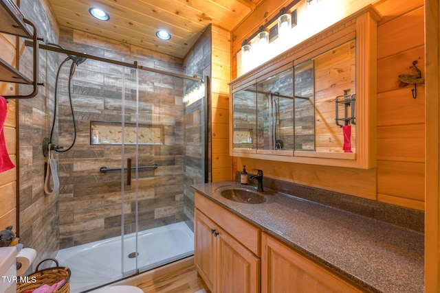 full bathroom with recessed lighting, wood walls, wood ceiling, vanity, and a shower stall