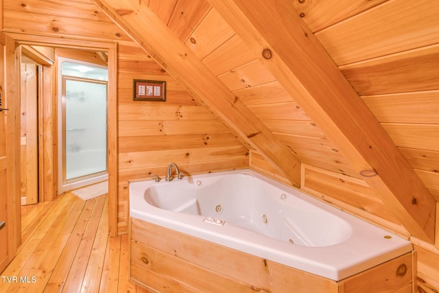 full bath featuring a jetted tub, wooden ceiling, wooden walls, and hardwood / wood-style floors