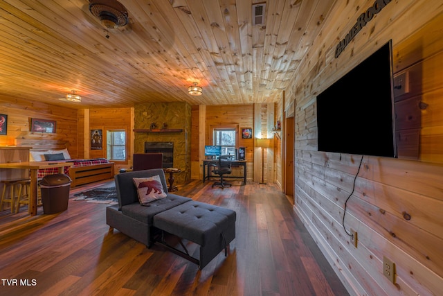 living room featuring hardwood / wood-style flooring, wood ceiling, wooden walls, and a stone fireplace