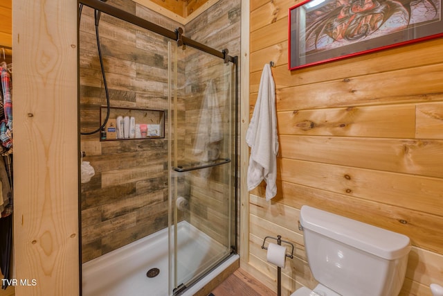 full bathroom with a stall shower, wooden walls, and toilet