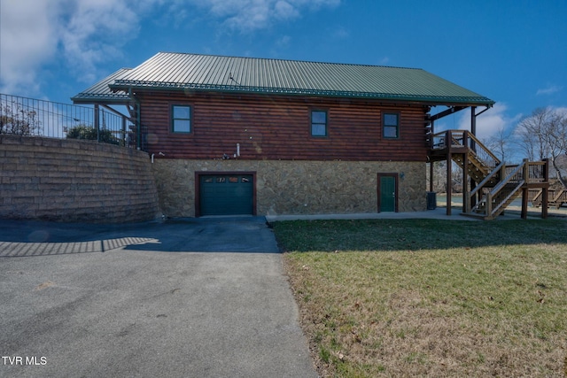 view of side of home featuring a lawn, stairway, log exterior, a garage, and stone siding