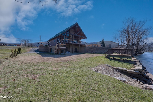 back of property featuring stairs, log siding, a deck, and a lawn