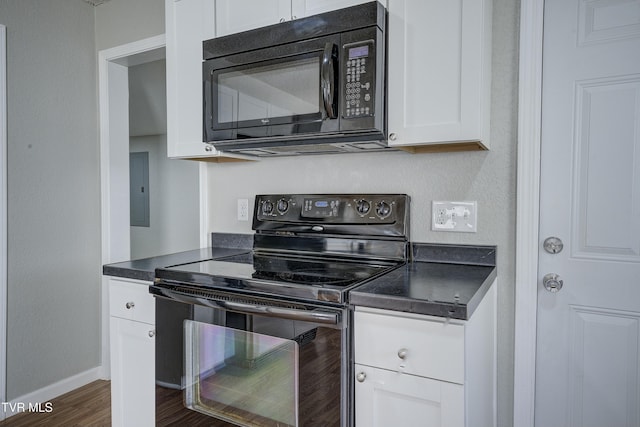 kitchen with dark wood-style flooring, dark countertops, white cabinets, electric panel, and black appliances