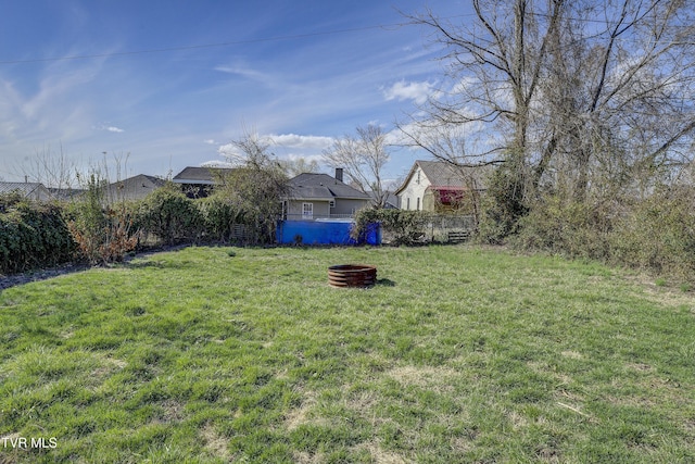 view of yard with a fire pit and fence