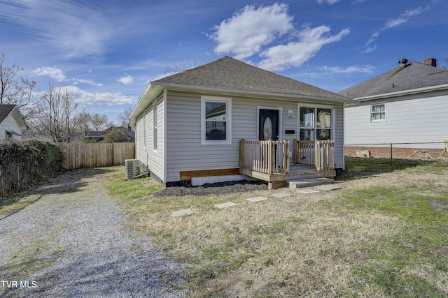 view of front of house with driveway, roof with shingles, fence, and central air condition unit