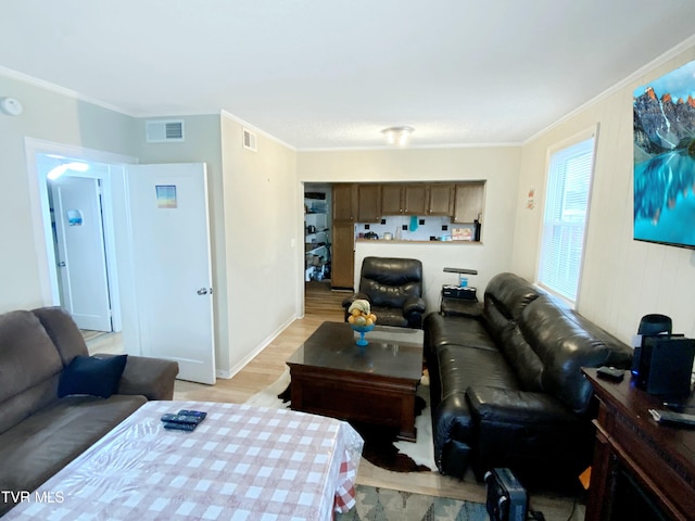 living area featuring ornamental molding, visible vents, and light wood finished floors