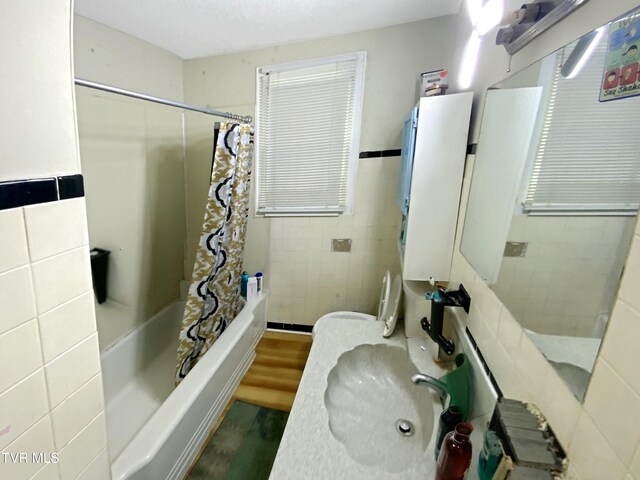 1536 Pineola Ave, Kingsport, TN 37664 - bathroom featuring a sink, wood finished floors, tile walls, and shower / bathtub combination with curtain