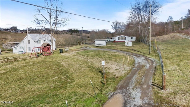 view of yard with driveway and a playground