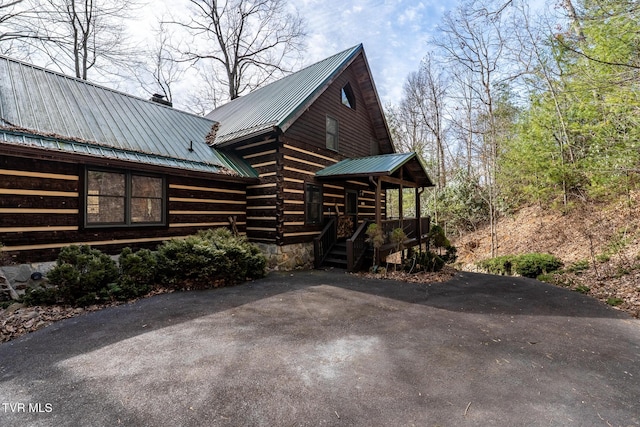 view of home's exterior with metal roof and a chimney