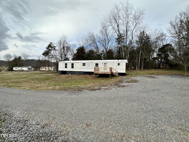 manufactured / mobile home with a deck and a front lawn