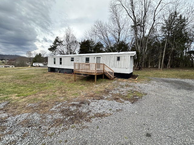 manufactured / mobile home with a front yard and a wooden deck