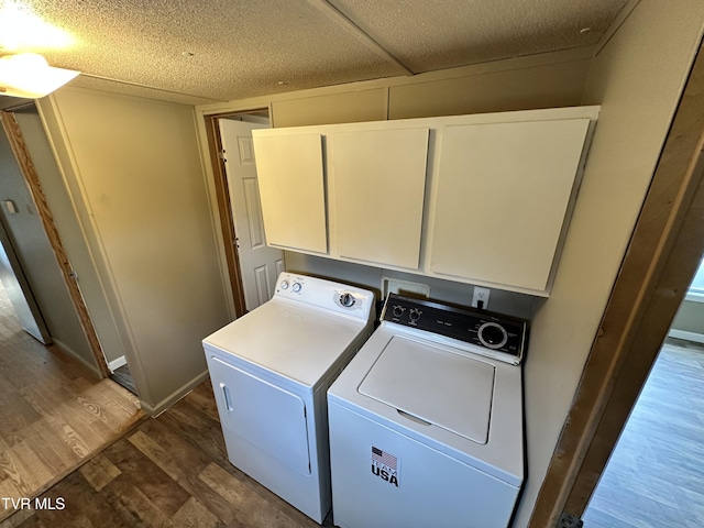 laundry room with cabinet space, a textured ceiling, dark wood-style floors, and washer and dryer