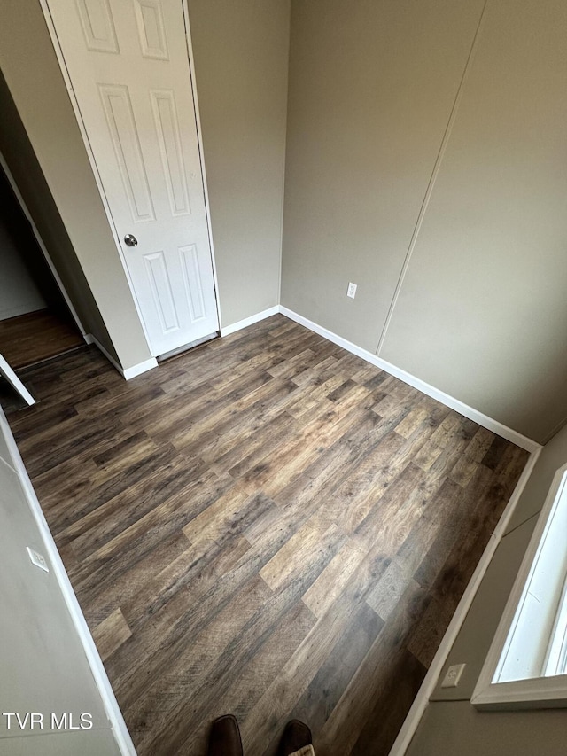 unfurnished bedroom featuring dark wood-style floors and baseboards