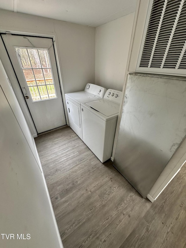 laundry room featuring light wood-style floors, laundry area, and independent washer and dryer