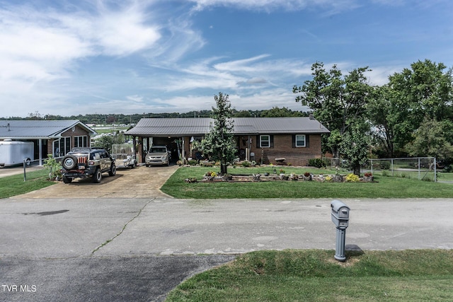 view of front of property featuring metal roof, brick siding, fence, concrete driveway, and a front yard