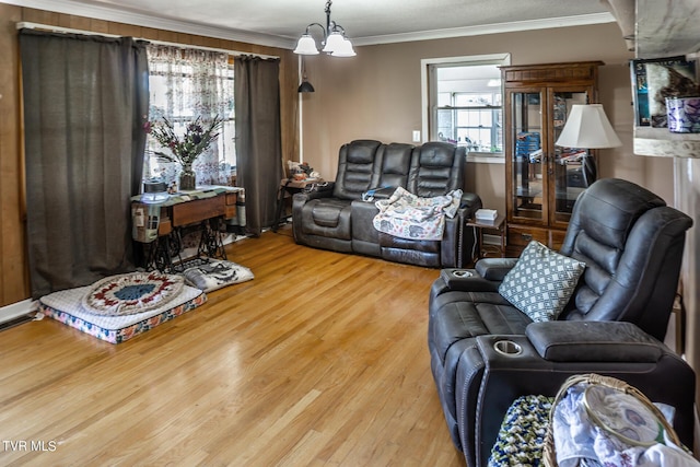 living room with a chandelier, crown molding, and wood finished floors