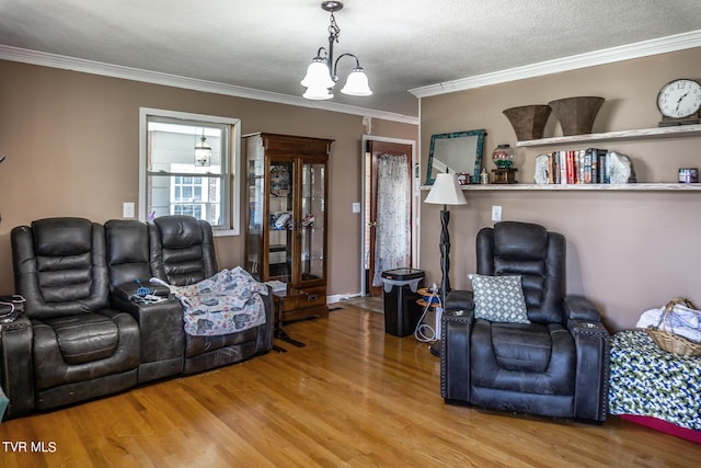 living room featuring ornamental molding, a chandelier, a textured ceiling, and wood finished floors