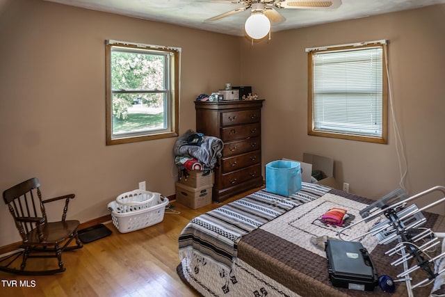 bedroom with ceiling fan, baseboards, and wood finished floors