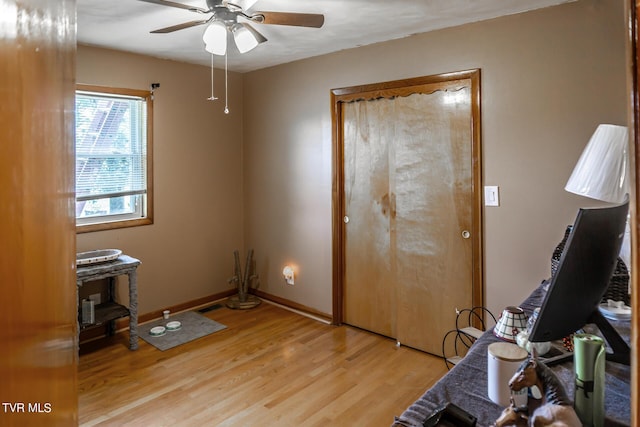 interior space with baseboards, ceiling fan, and light wood finished floors