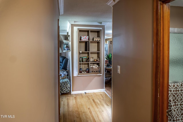 hall featuring baseboards and wood finished floors