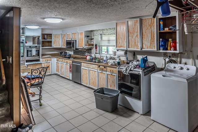 kitchen featuring stainless steel appliances, washer / clothes dryer, a sink, and open shelves