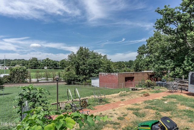 view of yard featuring an outbuilding, a pole building, and fence