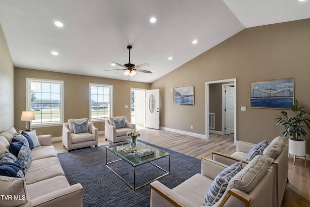 living room featuring vaulted ceiling, light wood-type flooring, baseboards, and recessed lighting