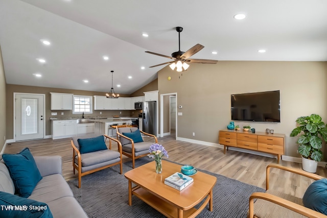 living area with recessed lighting, baseboards, vaulted ceiling, light wood-style floors, and ceiling fan with notable chandelier