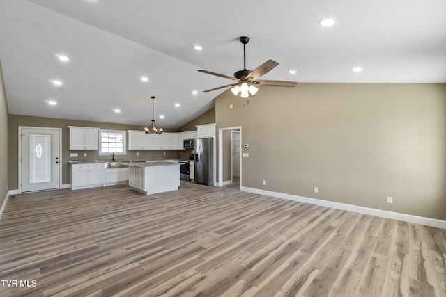 kitchen featuring white cabinets, appliances with stainless steel finishes, open floor plan, and a center island