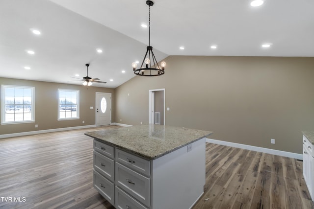 kitchen featuring lofted ceiling, hanging light fixtures, light wood-style flooring, open floor plan, and a kitchen island