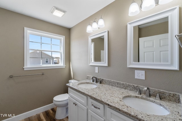 bathroom featuring wood finished floors, a sink, toilet, and baseboards