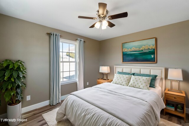 bedroom featuring ceiling fan, wood finished floors, and baseboards