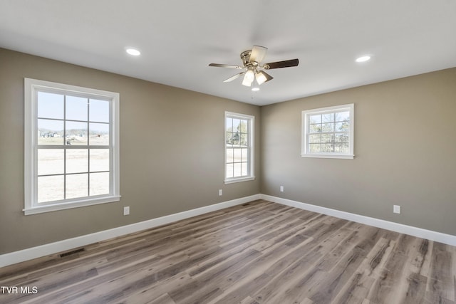 empty room featuring baseboards, wood finished floors, and recessed lighting