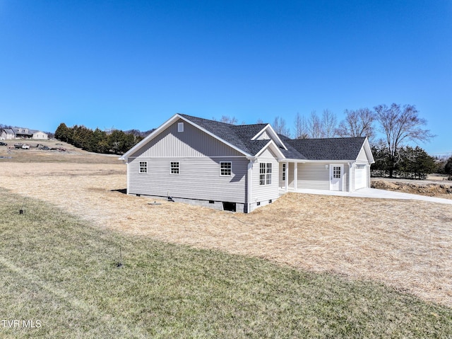 view of home's exterior with a garage, roof with shingles, and a lawn