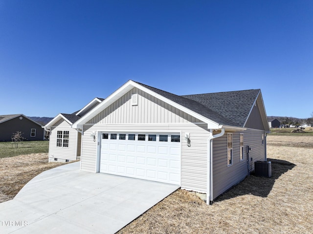 exterior space with a garage, driveway, roof with shingles, and central air condition unit