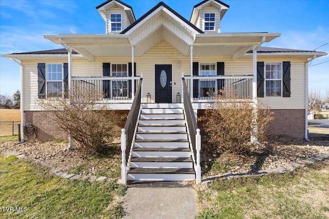 view of front of home featuring covered porch, brick siding, and stairway