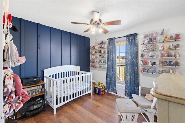 bedroom featuring a ceiling fan, a textured ceiling, and wood finished floors